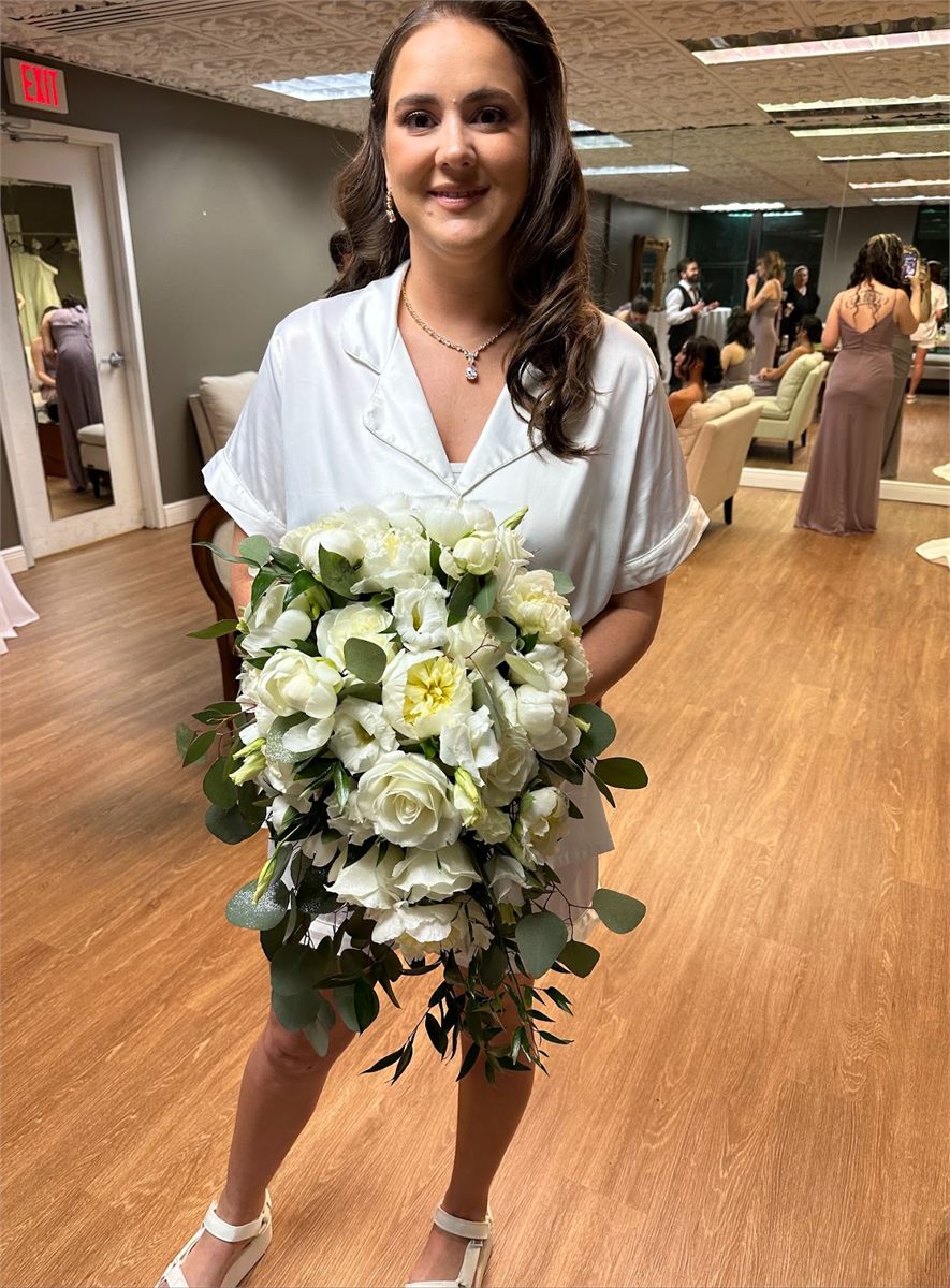 Bride holding a bouquet of white roses and lisianthus with eucalyptus