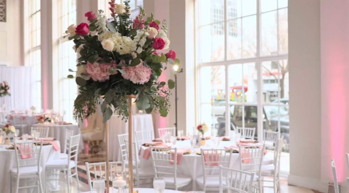 Tall pink and white centerpiece in a bright reception room