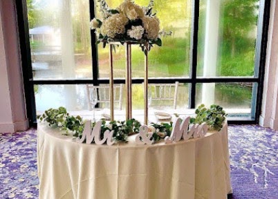 Sweetheart table with Mr and Mrs lettering, a greenery garland and tall white centerpieces