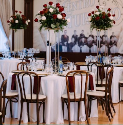 Reception hall with tall red and white rose centerpieces on round tables