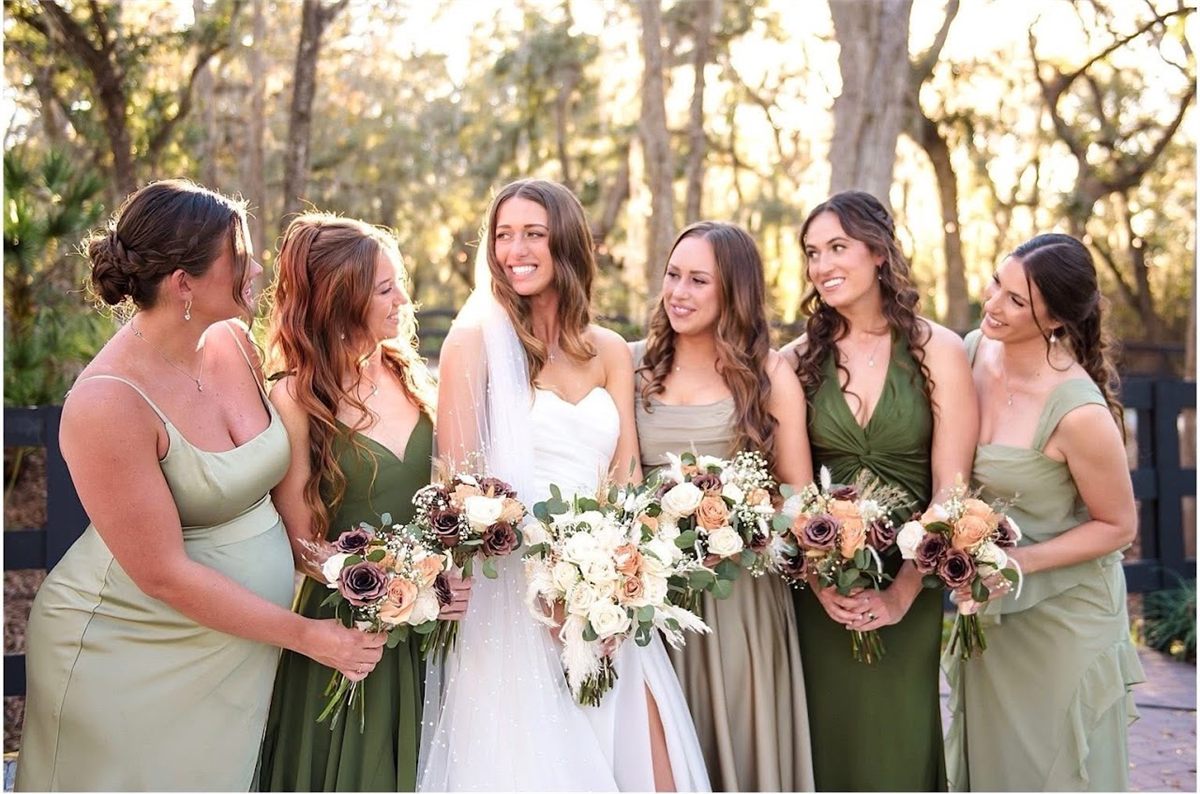 Bride and five bridesmaids in green dresses holding bouquets outdoors