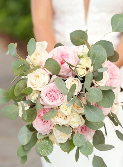 Bride holding a bouquet of pink and cream garden roses with eucalyptus